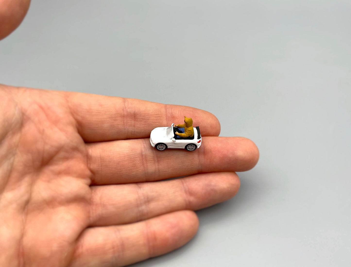 Miniature Boy in Electric Toy Car. 1:64 Scale Human Figure